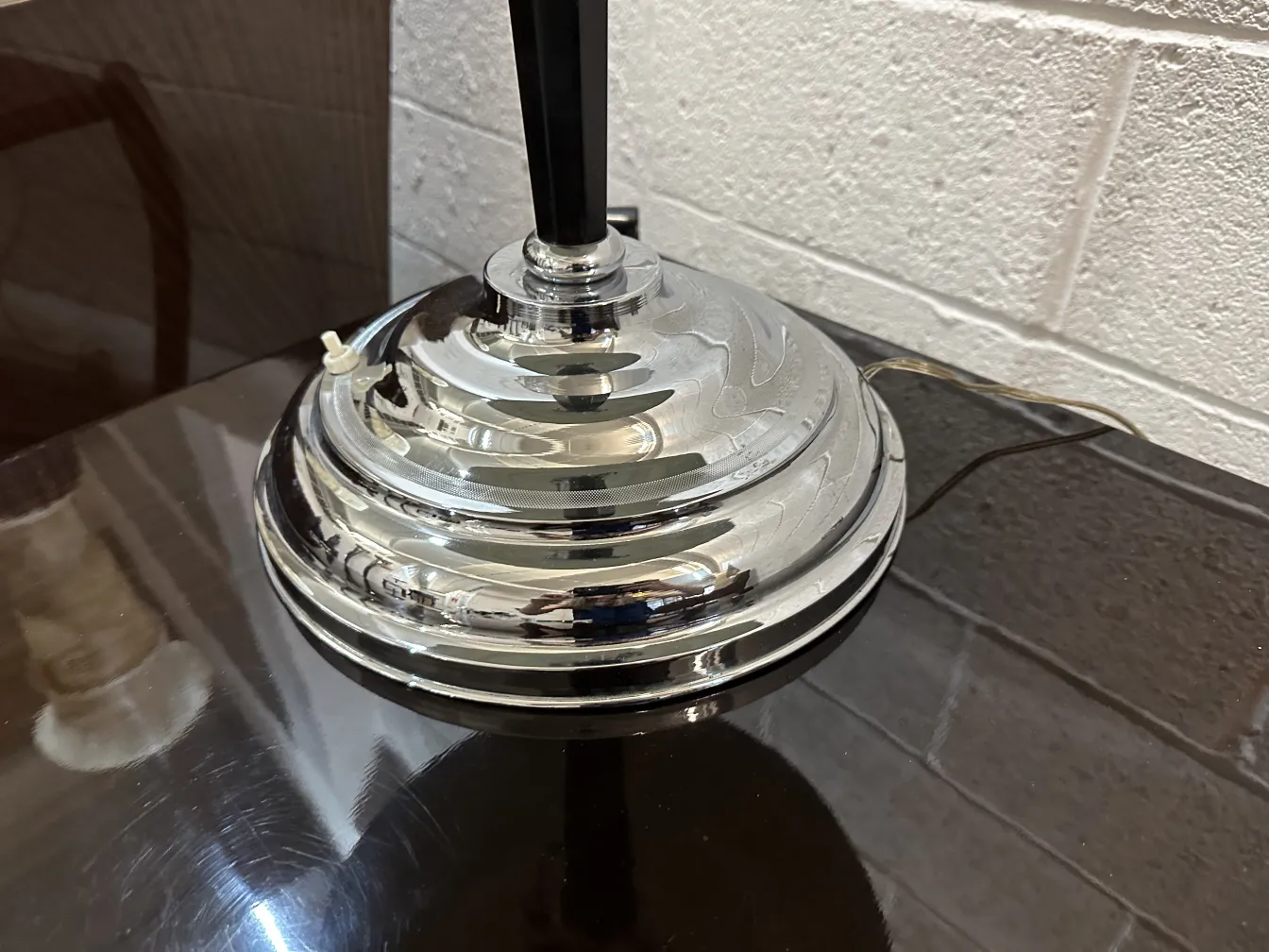 Lampada da tavolo antica con base lucida, inserita in un contesto moderno.