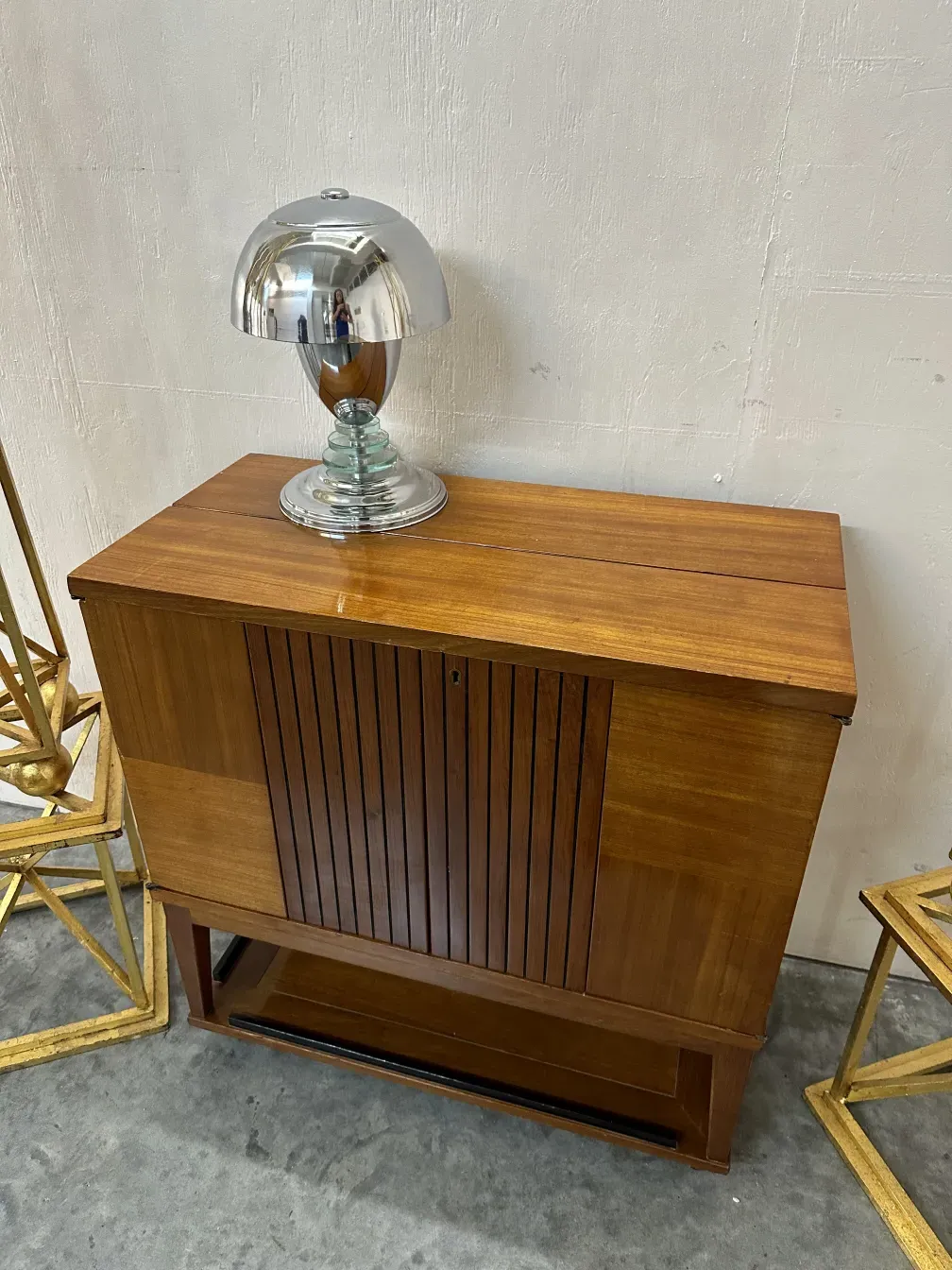 lampara de mesa antigua con una base de cristal y diseño elegante, ubicada junto a muebles de madera