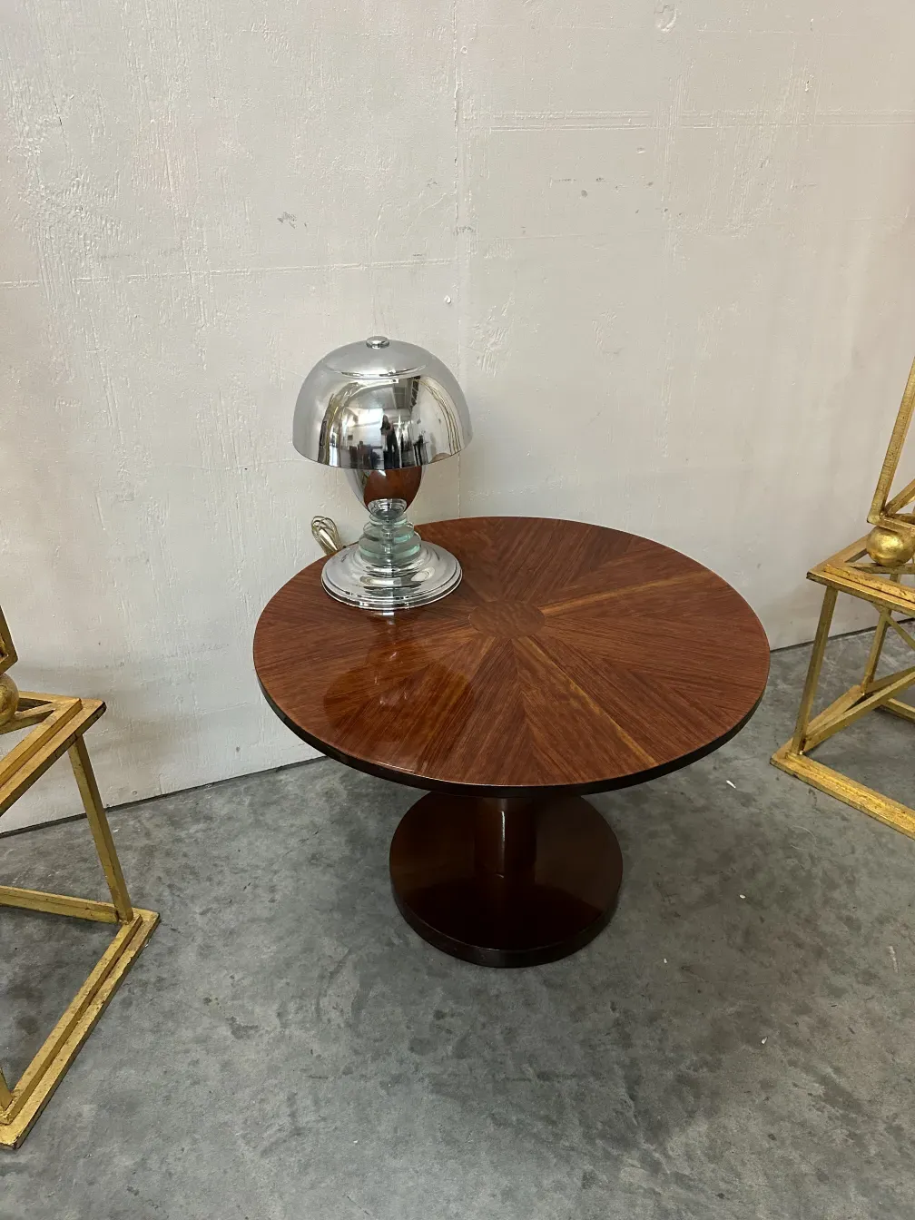 antigua lámpara de mesa con una base elegante y curva, entorno de muebles dorados y mesa redonda