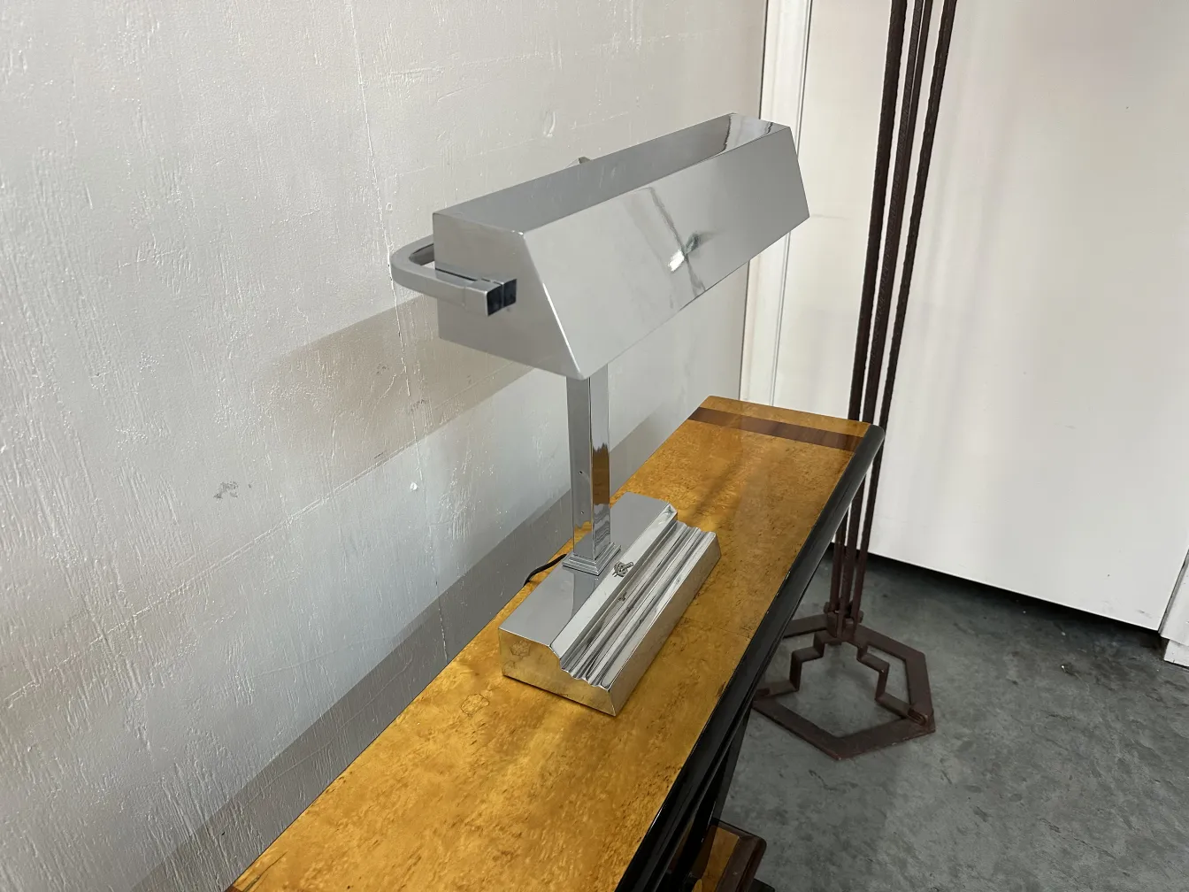 luminária de mesa antiga com base cromada e sombra retangular, em um ambiente moderno