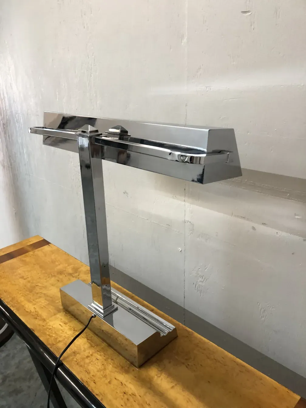 lampara de mesa antigua con base de acabado brillante sobre mesa de madera clara