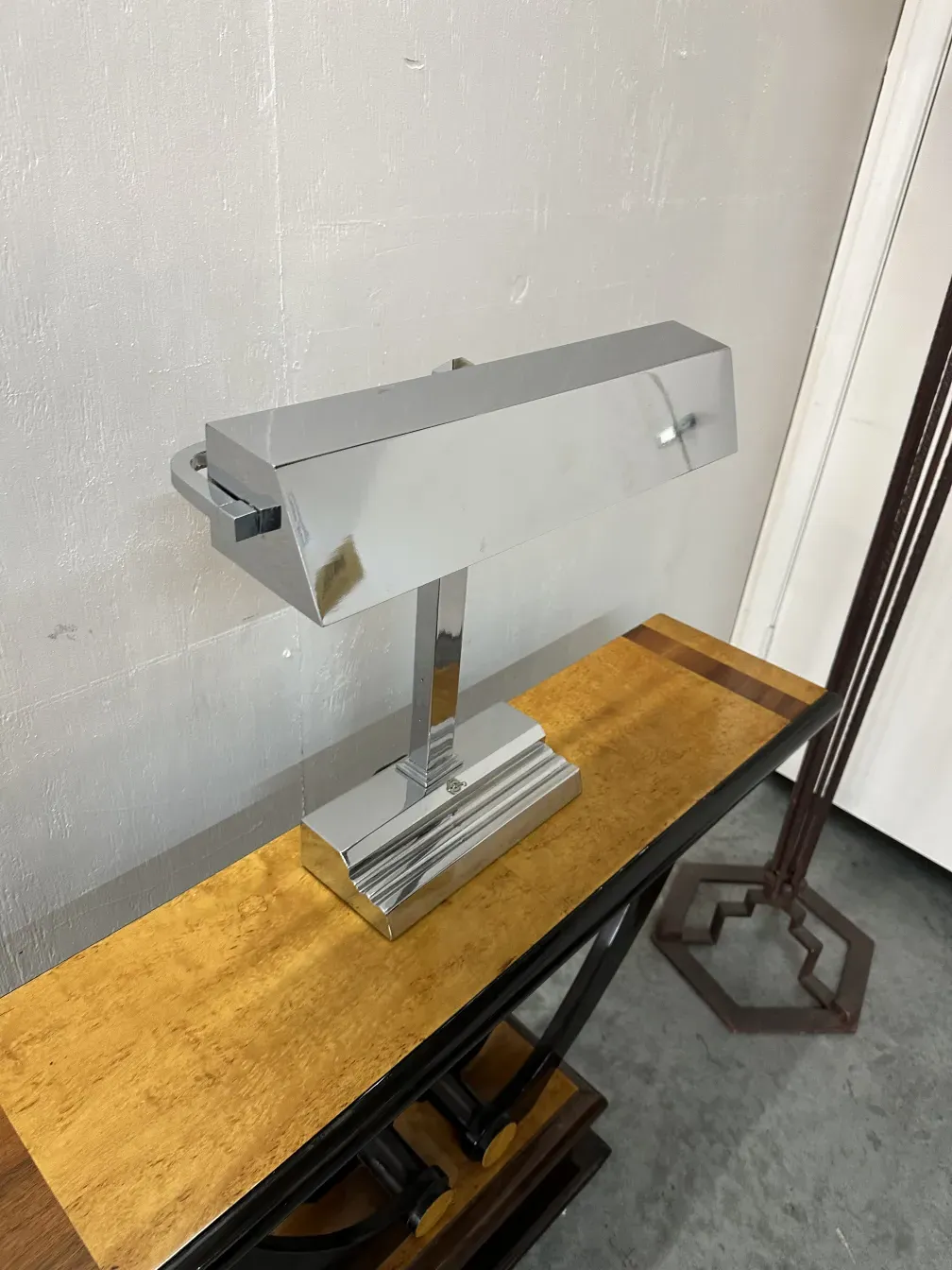 lampara de mesa antigua sobre mesa de madera clara, elegante y con detalle de metal