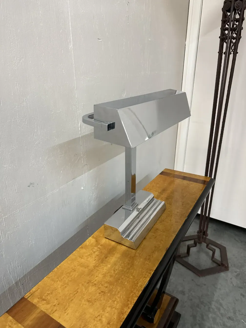 luminaria antiga de mesa em base cromada em uma mesa moderna