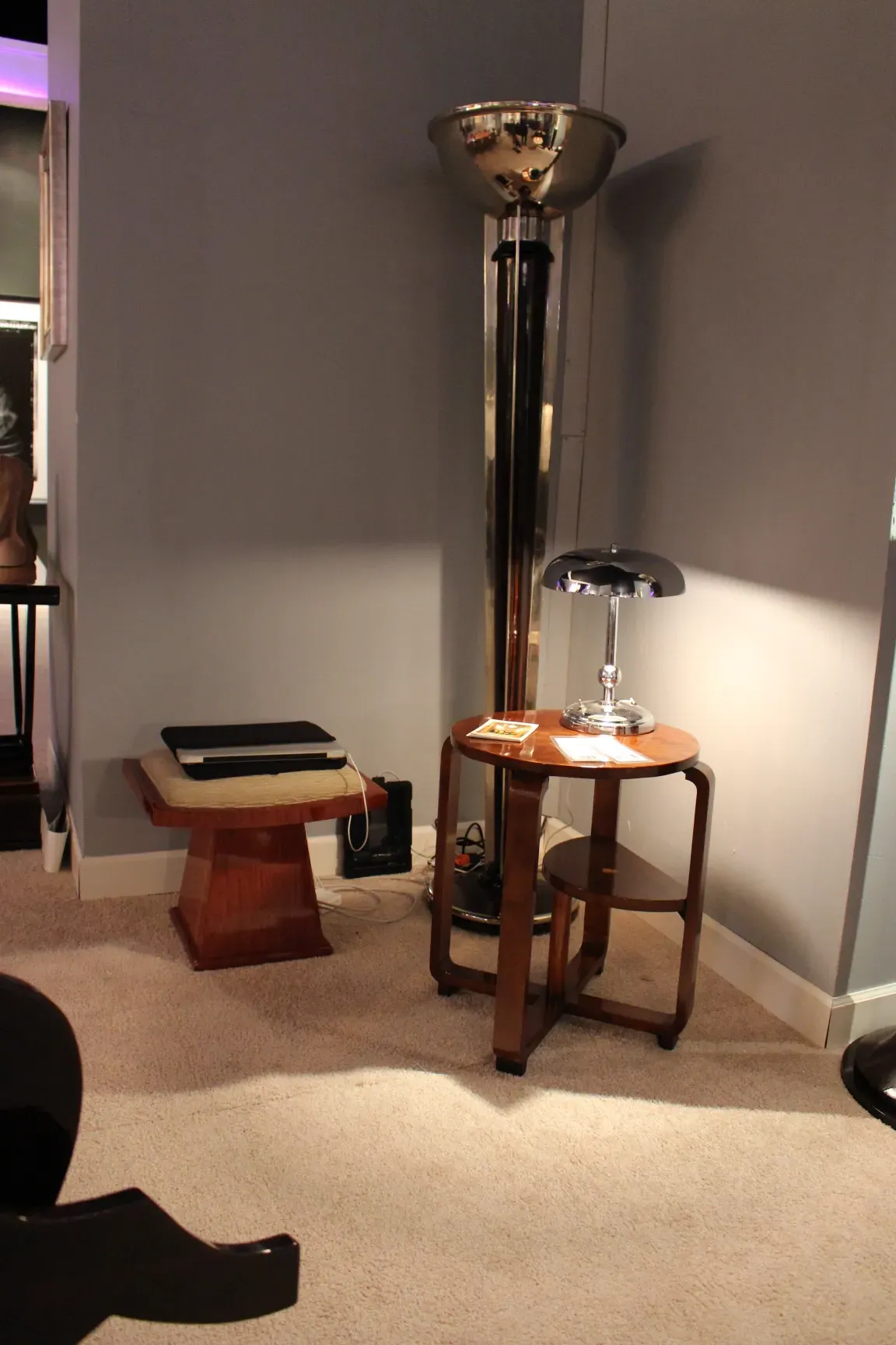 Lampada da tavolo antica con base elegante e luce soffusa, accompagnata da un tavolo in legno.