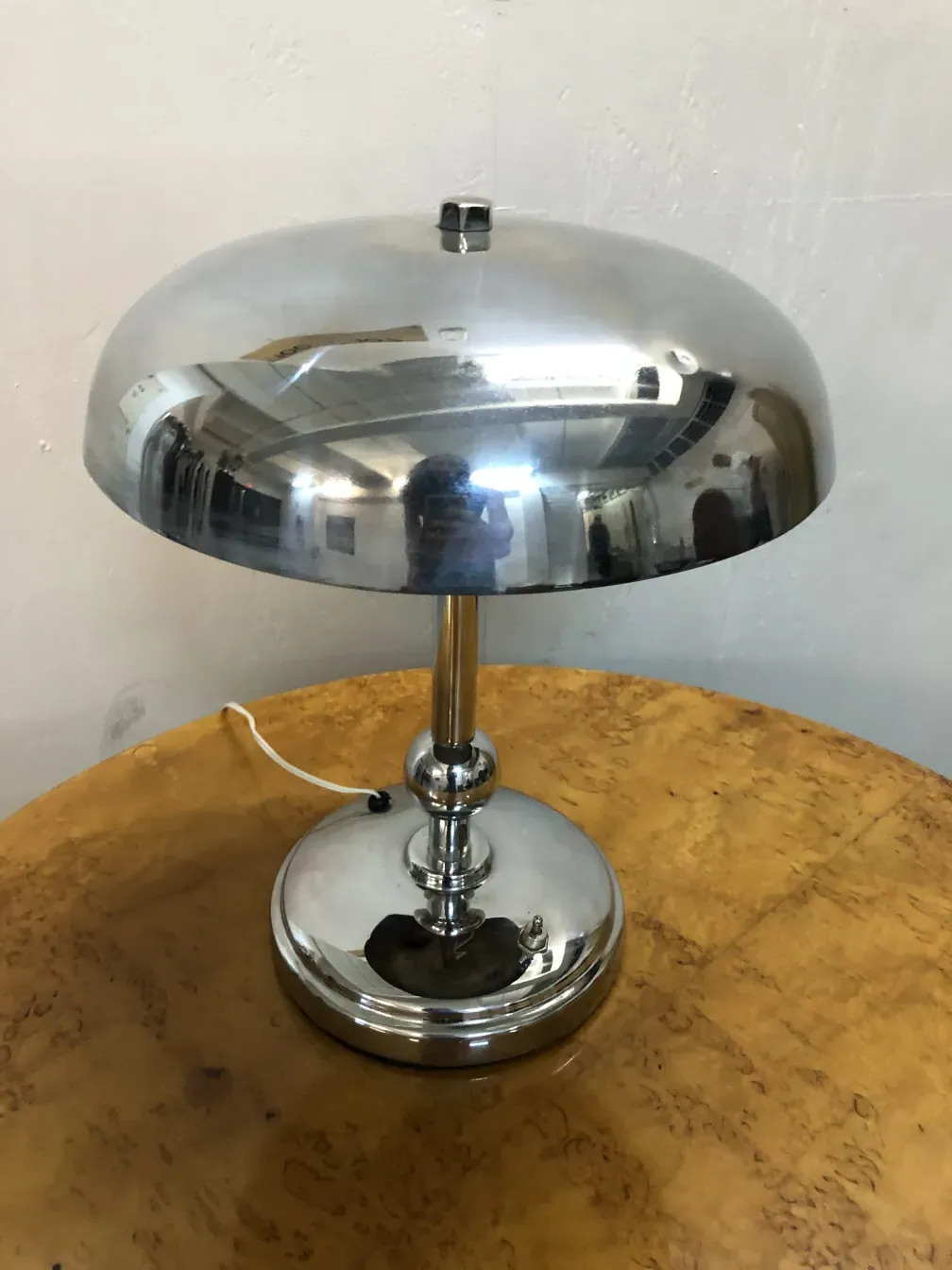 Lampe de bureau ancienne avec un design élégant et une base ronde dans un cadre chaleureux.