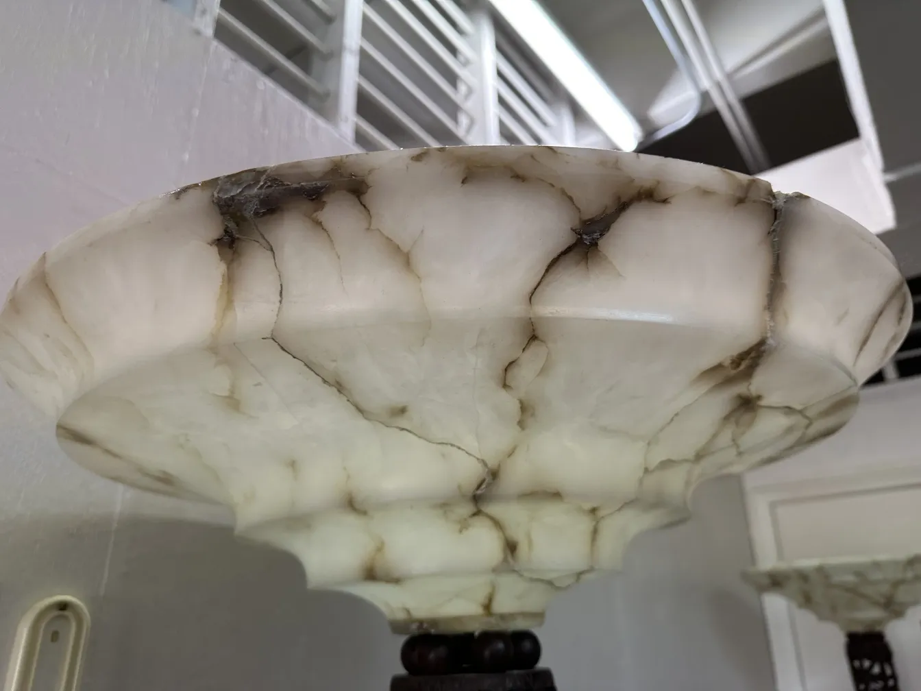 Duas lâmpadas de piso antigas com bases decorativas, em um ambiente elegante.