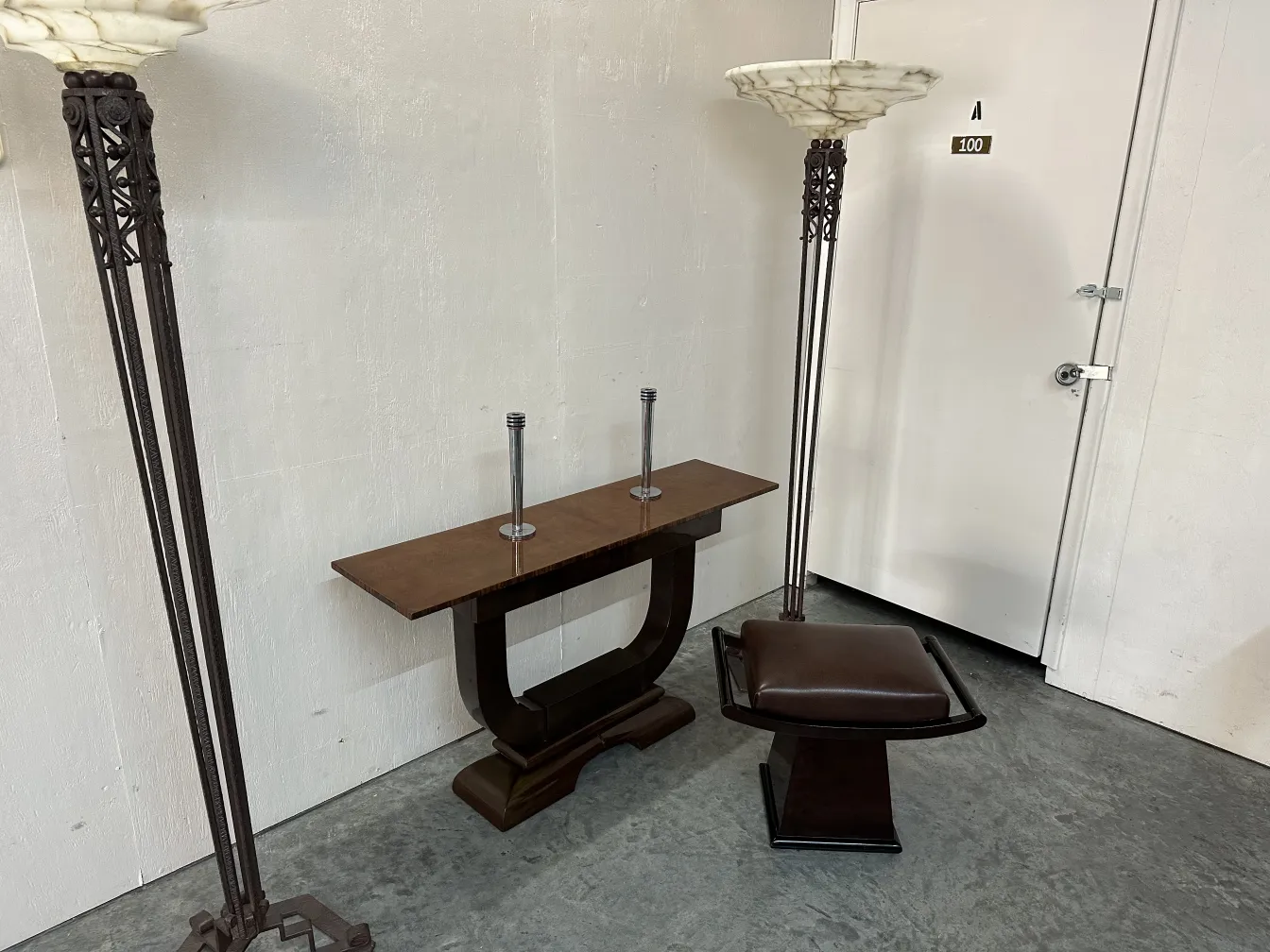 deux lampadaires anciens dans un cadre neutre avec un design simple, une table et un tabouret