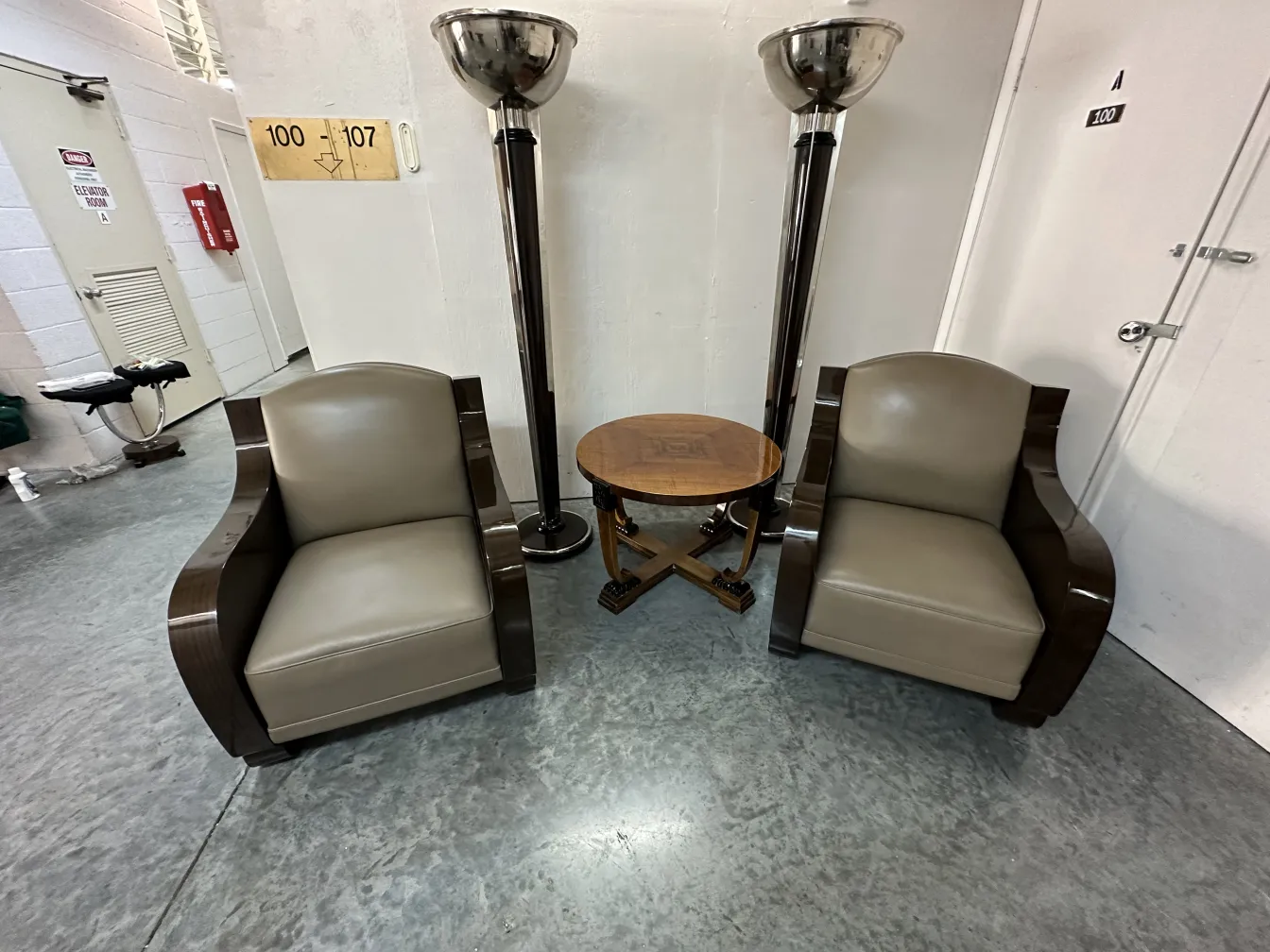 Dos lámparas de pie antiguas junto a sillones en un ambiente acogedor.