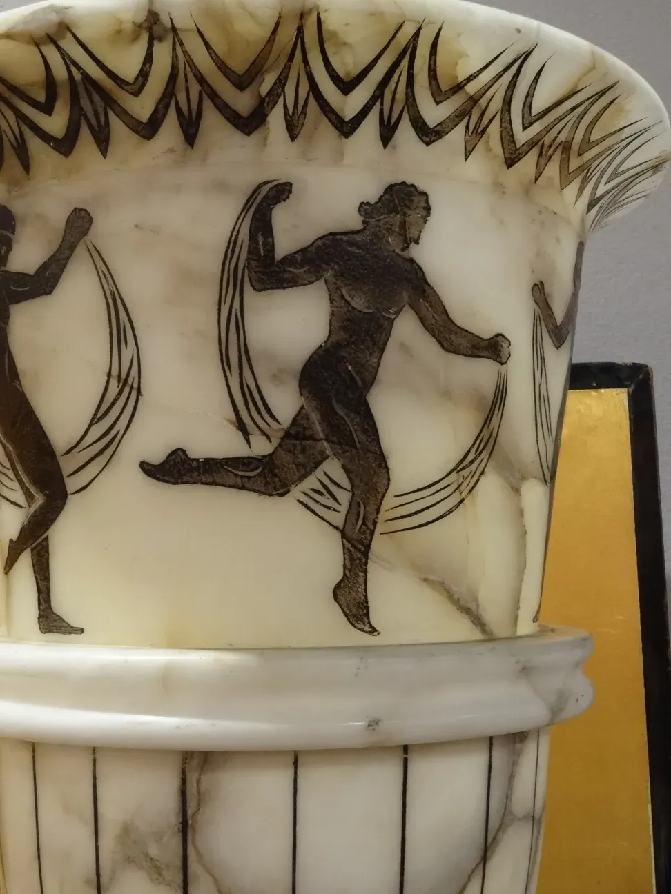 dos lámparas de pie antiguas con figuras decorativas en el cuerpo, en un ambiente elegante y clásico.