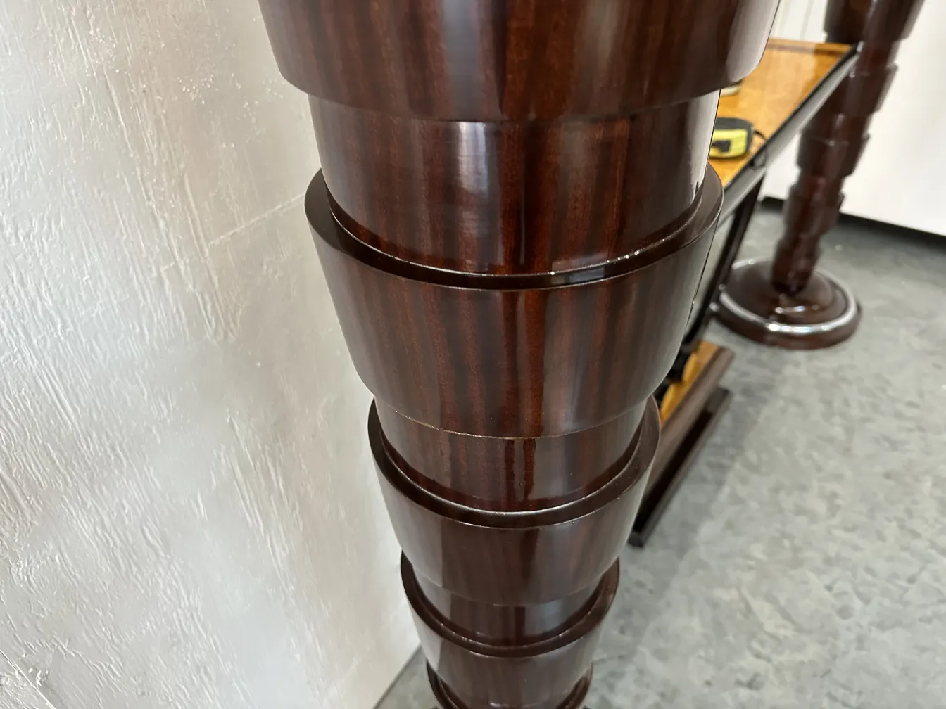 Side view of 2 antique floor lamps, featuring tall and slender bases