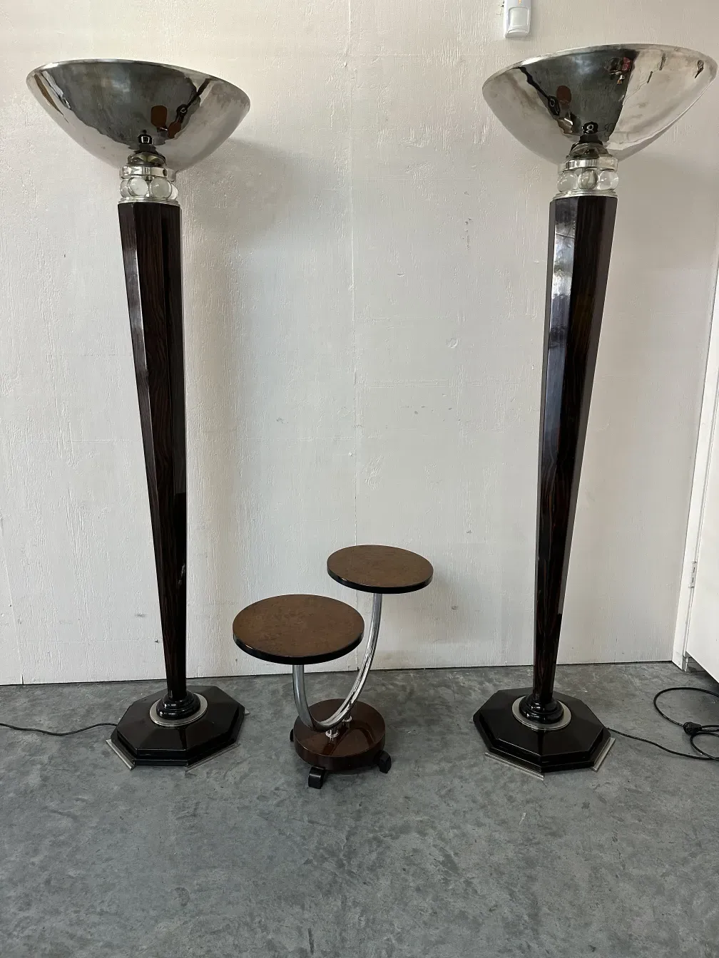 2 lampadaires anciens avec bases octogonales et abat-jours larges, à côté de tables basses.