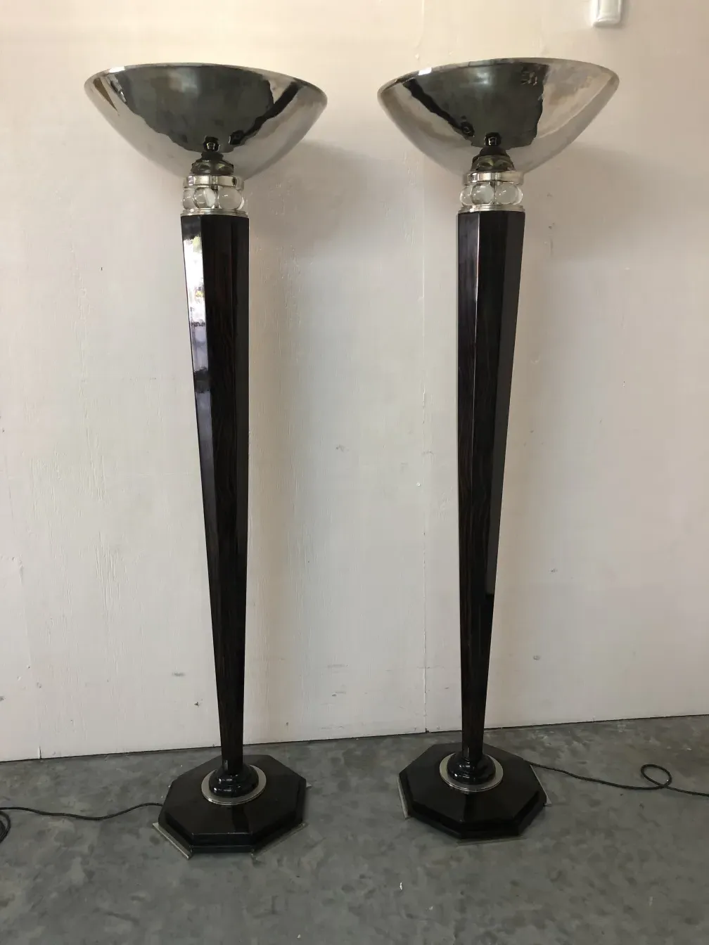 two floor lamps with octagonal bases and shiny shades in a neutral setting