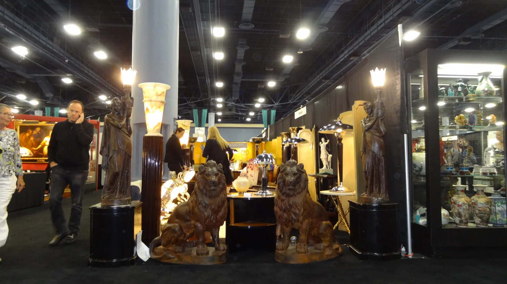 vista de dos antiguas lámparas de pie con esculturas de leones junto a figuras decorativas