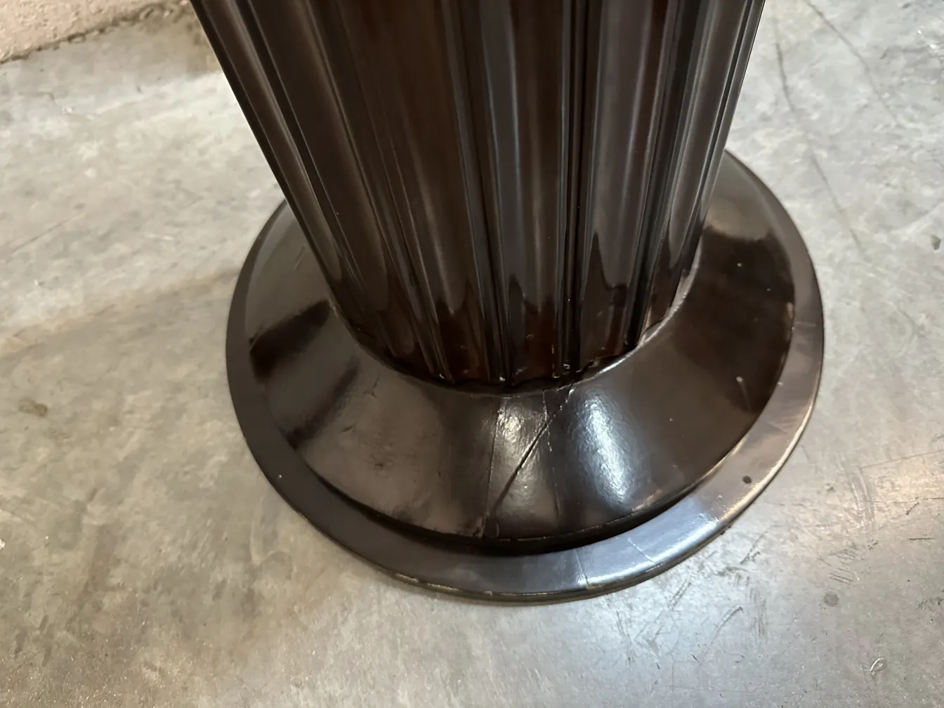 Détails de 2 lampadaires anciens avec large base et design distinctif dans un environnement neutre