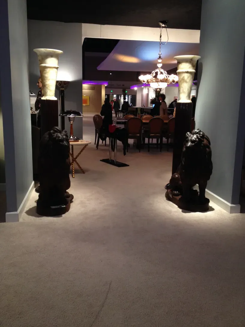 two antique floor lamps, one on each side, in an elegant setting with chairs and table in the background