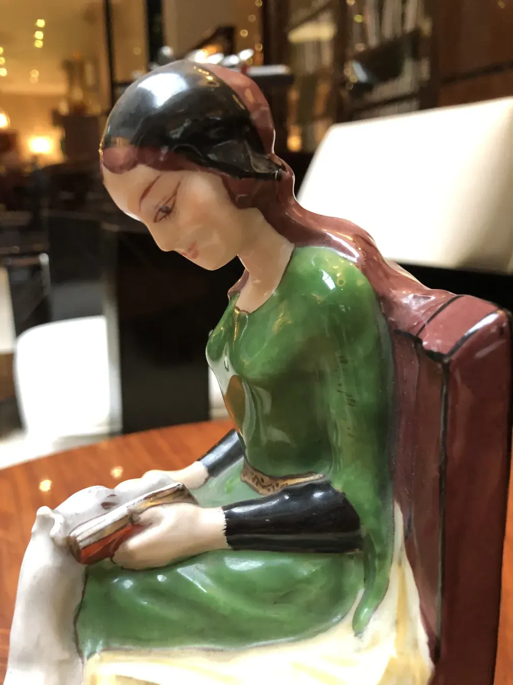 Antigua aprieta libros con figura de mujer sosteniendo un libro.