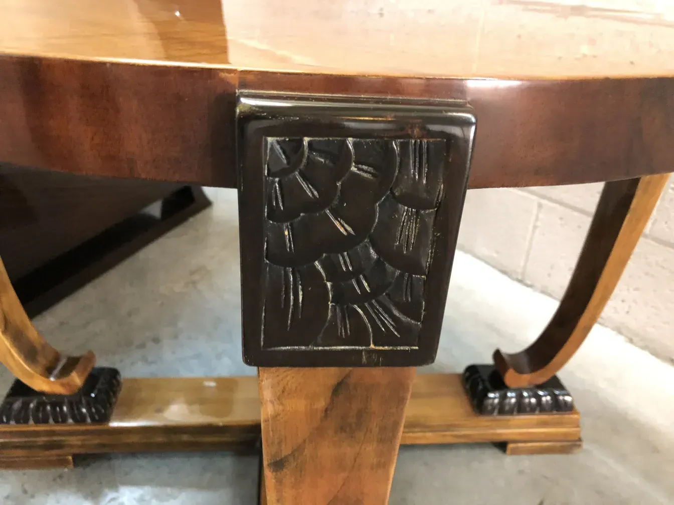 Antiker Couchtisch mit geschnitztem Design an der Basis, warme Atmosphäre.