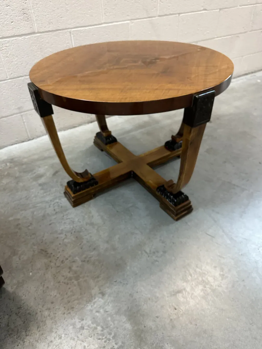 antiker Couchtisch mit geschwungenem Design und auffälligen Beinen in einem minimalistischen Umfeld