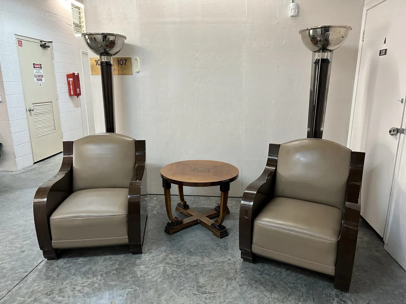 Mesa ratona antigua, con sillones en un salón moderno.