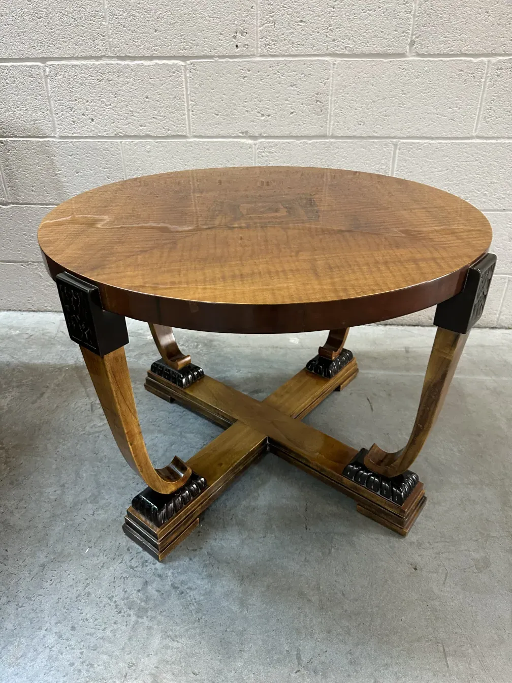 Mesa ratona antigua con detalles decorativos, en un ambiente neutro