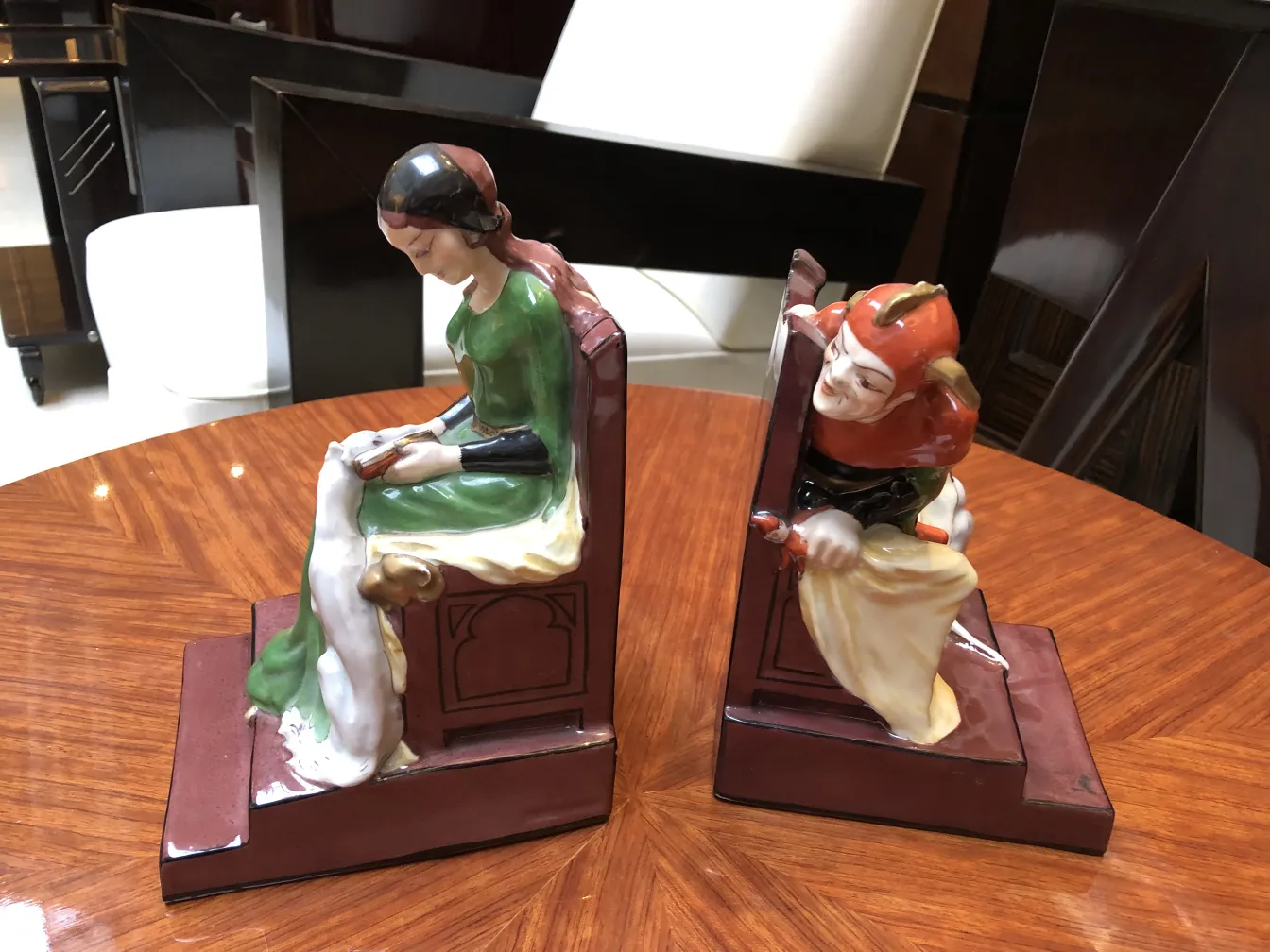 装飾芸術スタイルのフィギュアを持つブックエンド、女性と道化師がテーブルの上に。