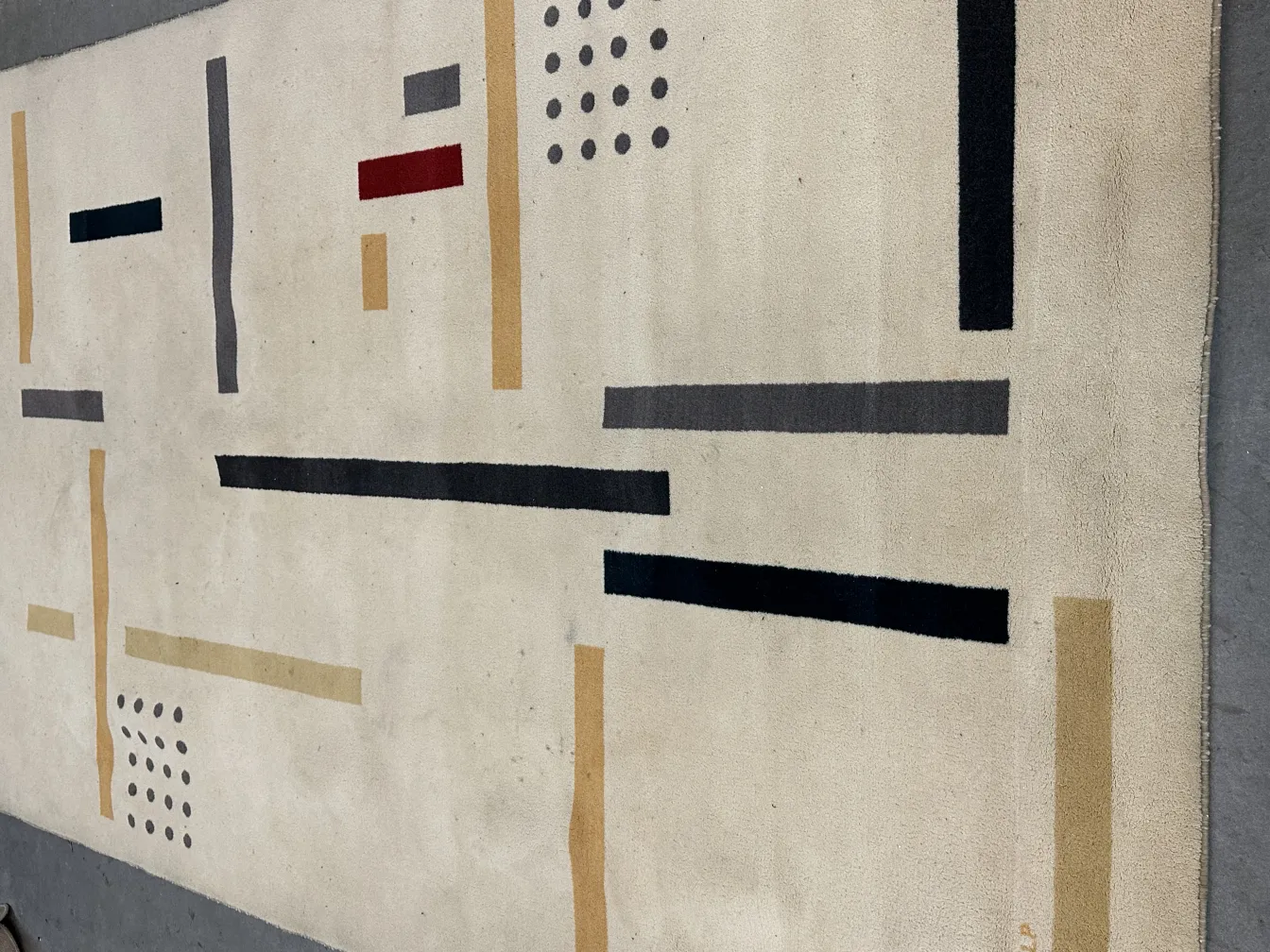 antique carpet with geometric design in light colors