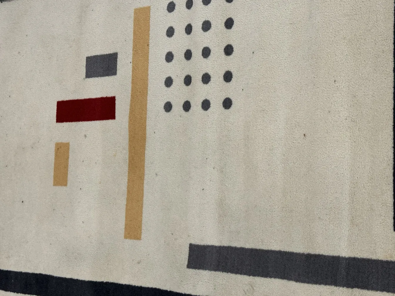 tapis ancien avec des formes géométriques dans des couleurs neutres