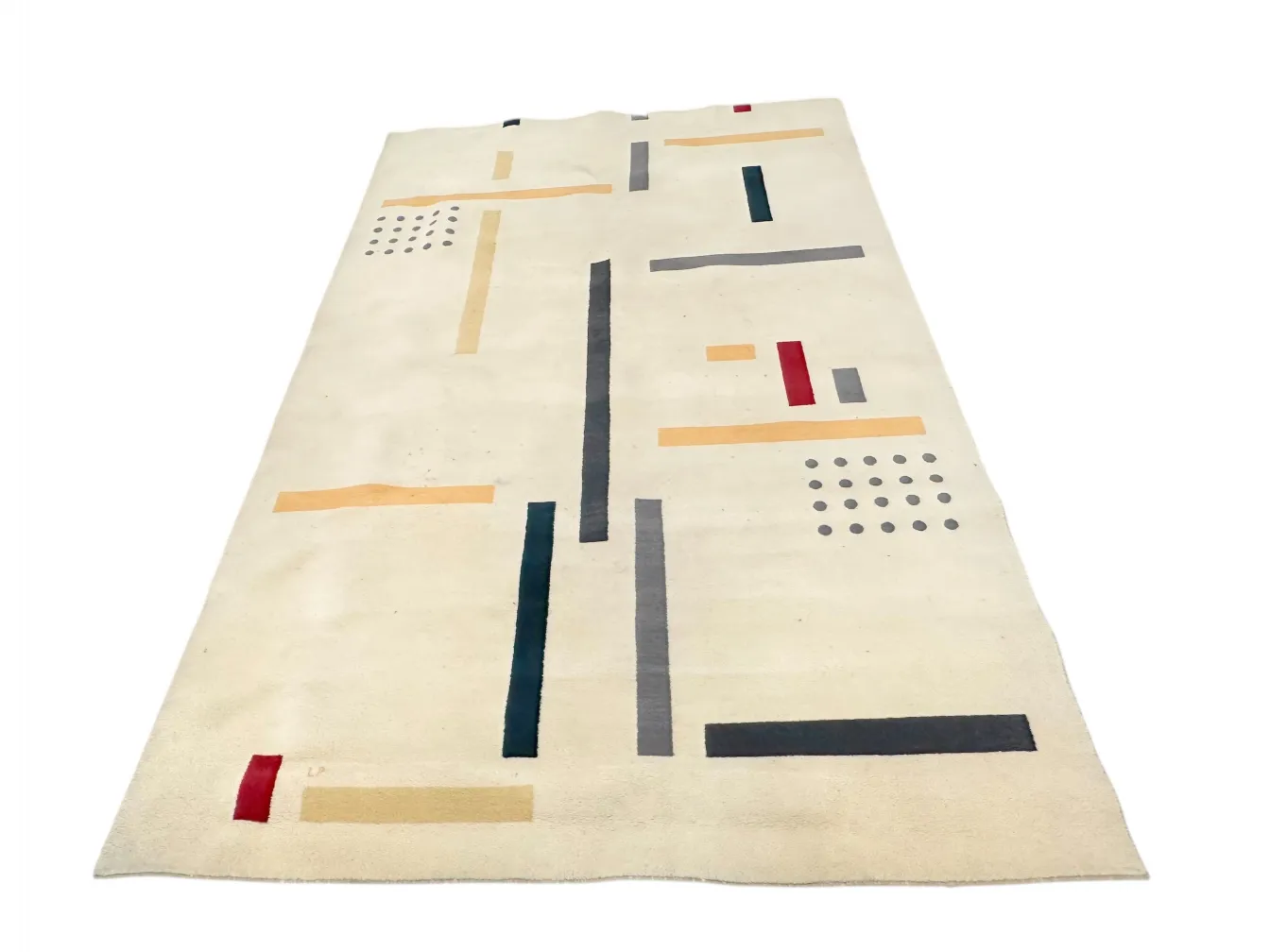 tapis ancien avec motifs géométriques colorés sur fond clair
