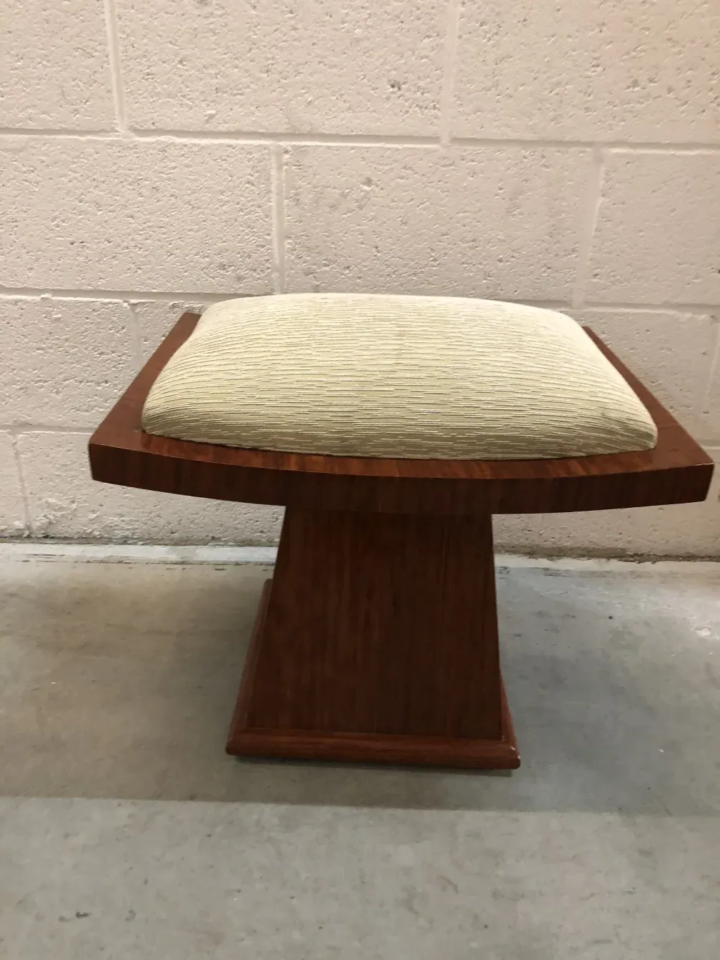 Ancien tabouret avec assise confortable, vue latérale dans un cadre neutre.