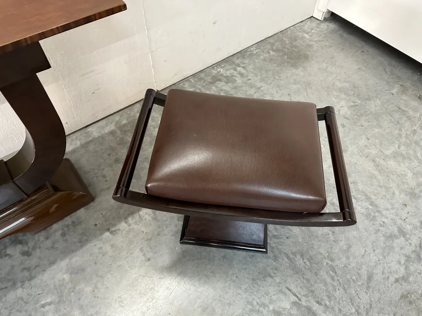 tabouret ancien avec assise rembourrée et base solide dans un cadre contemporain