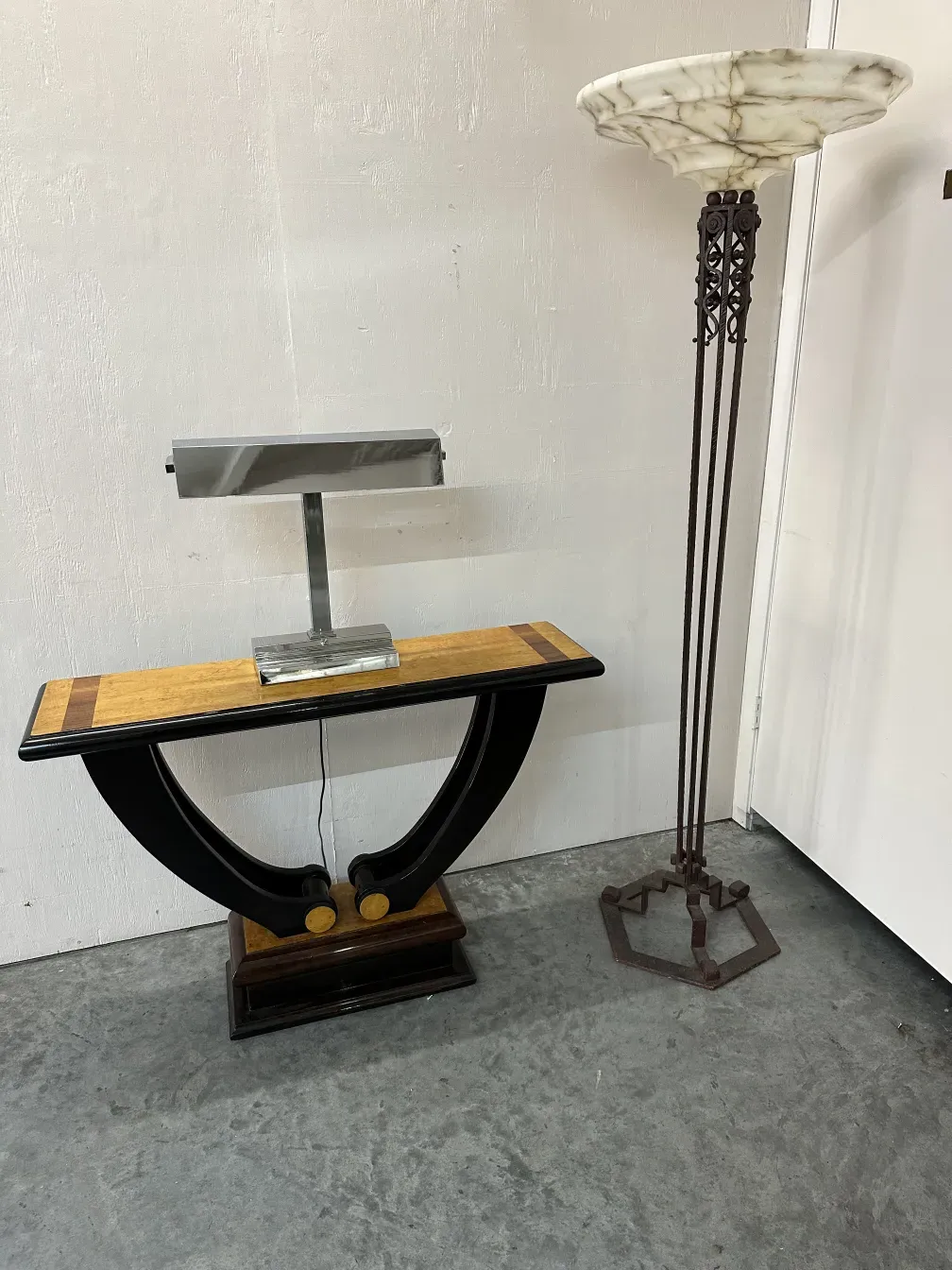 sgabello antico con forma curvata e dettagli alla base