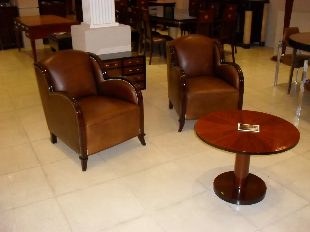 Mesinha antiga com design redondo em sala com poltronas