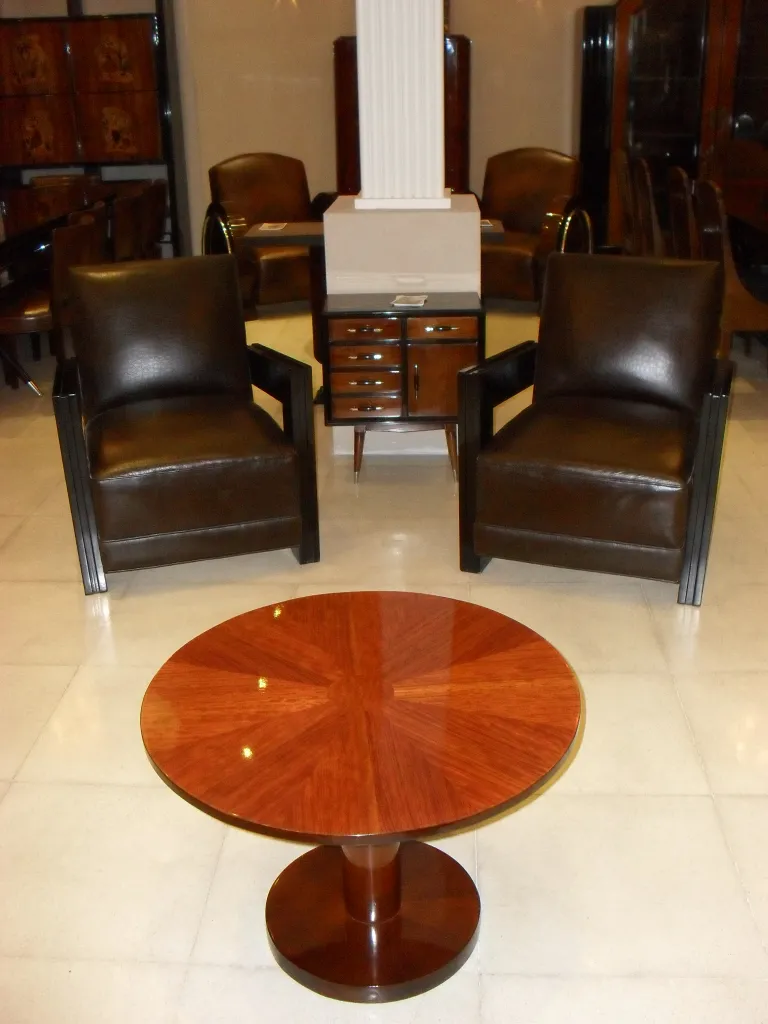 mesinha antiga redonda com pernas curtas em sala elegante com cadeiras escuras