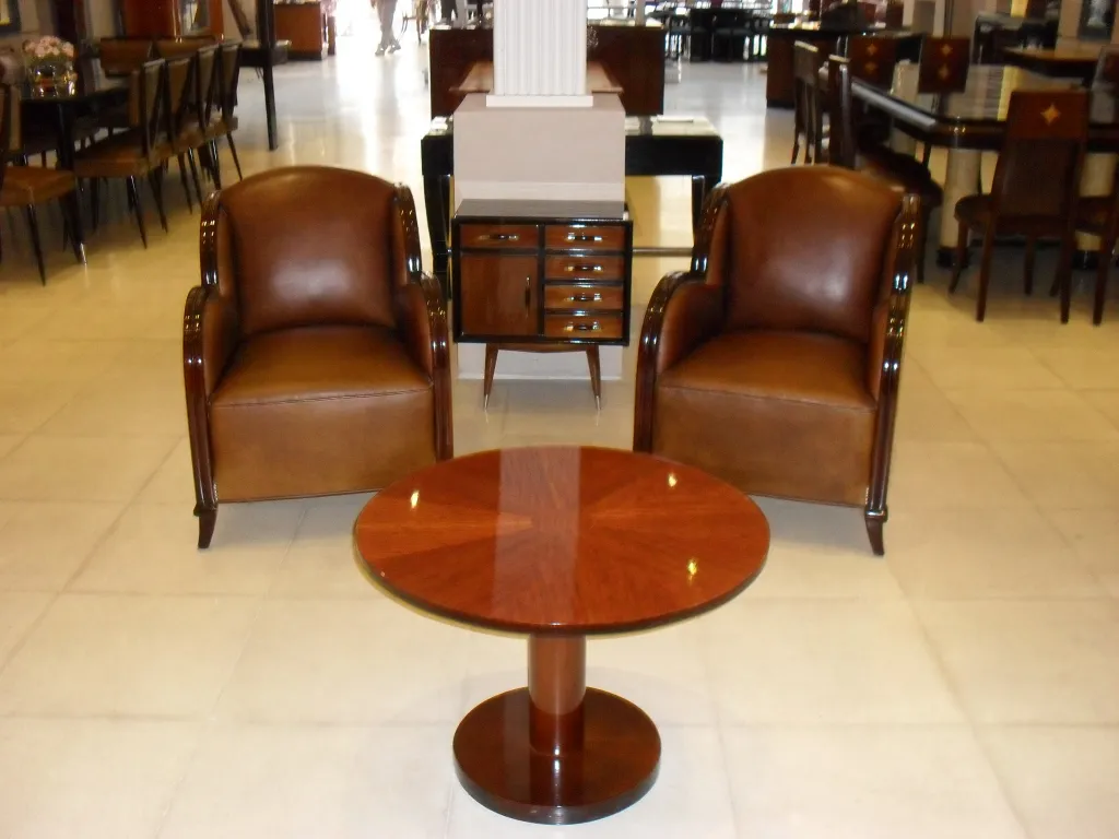 mesita antigua en un salón con sillones marrones