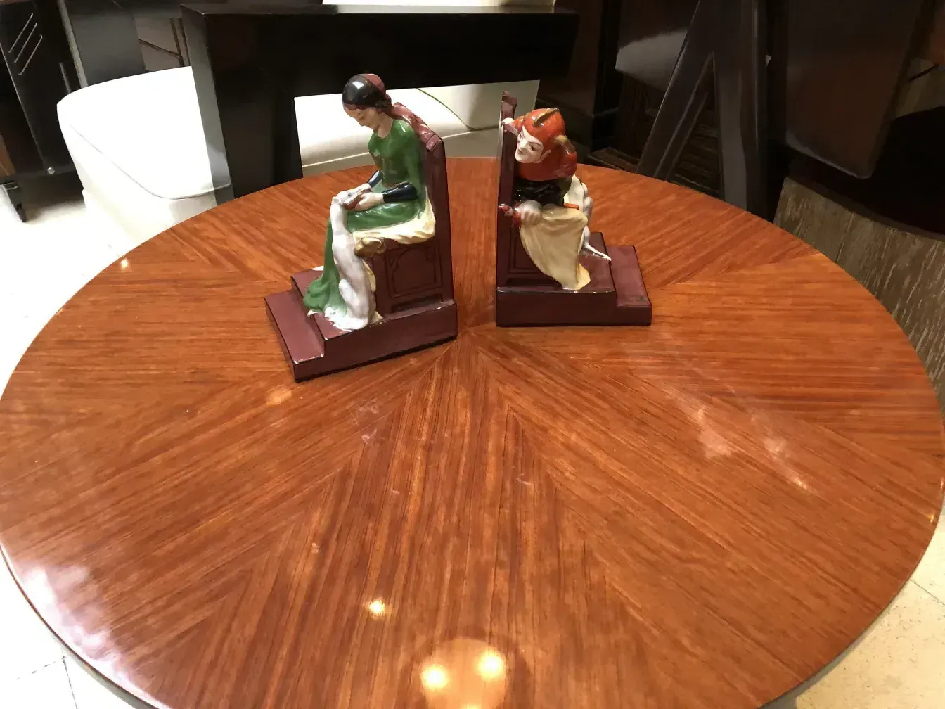 Suportes para livros antigos com figuras decorativas em uma mesa.