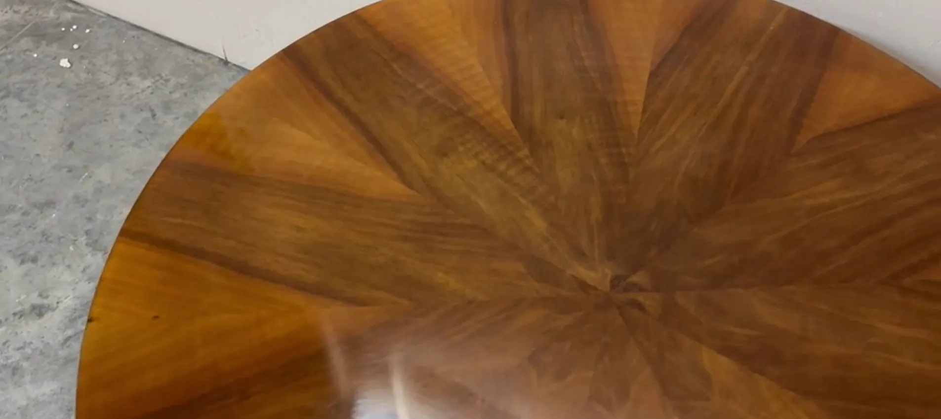 Tavolo rotondo antico con design in legno dettagliato, completato da un ambiente moderno.