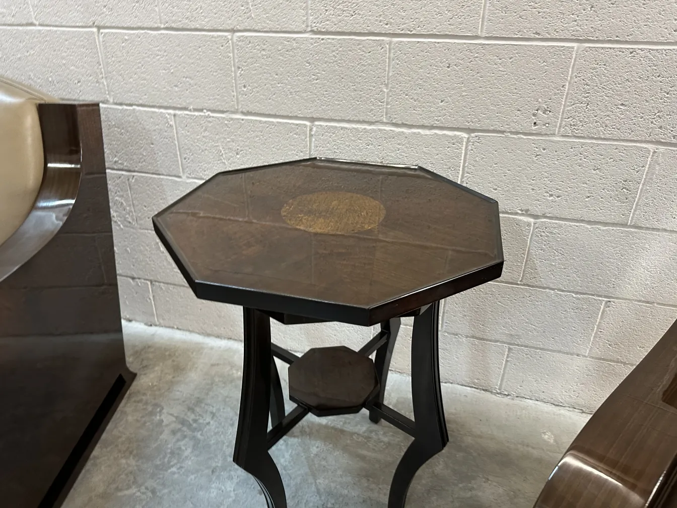 Antique small table with support base, in a bright and open environment.