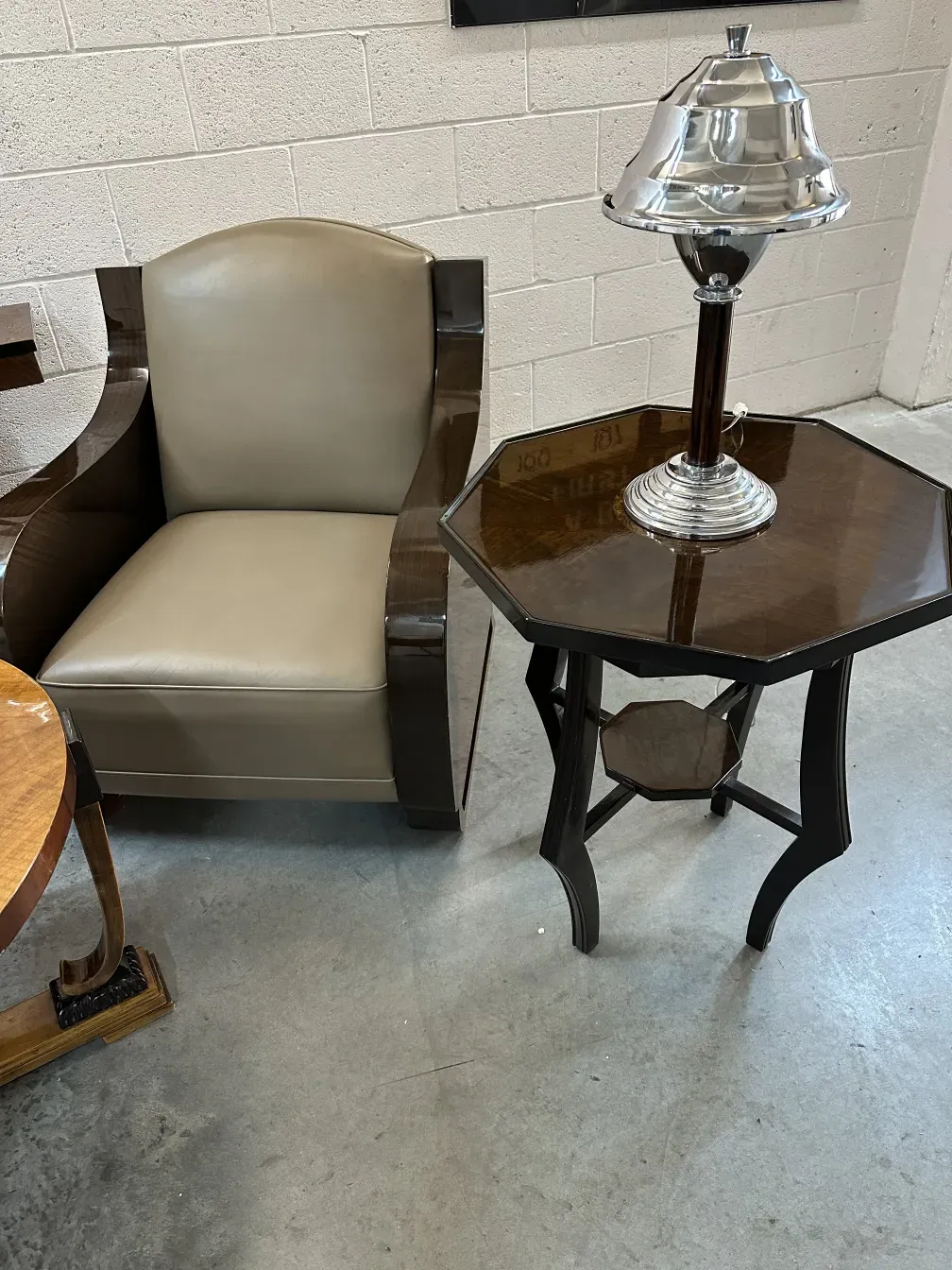 mesita antigua con lámpara decorativa y sillón