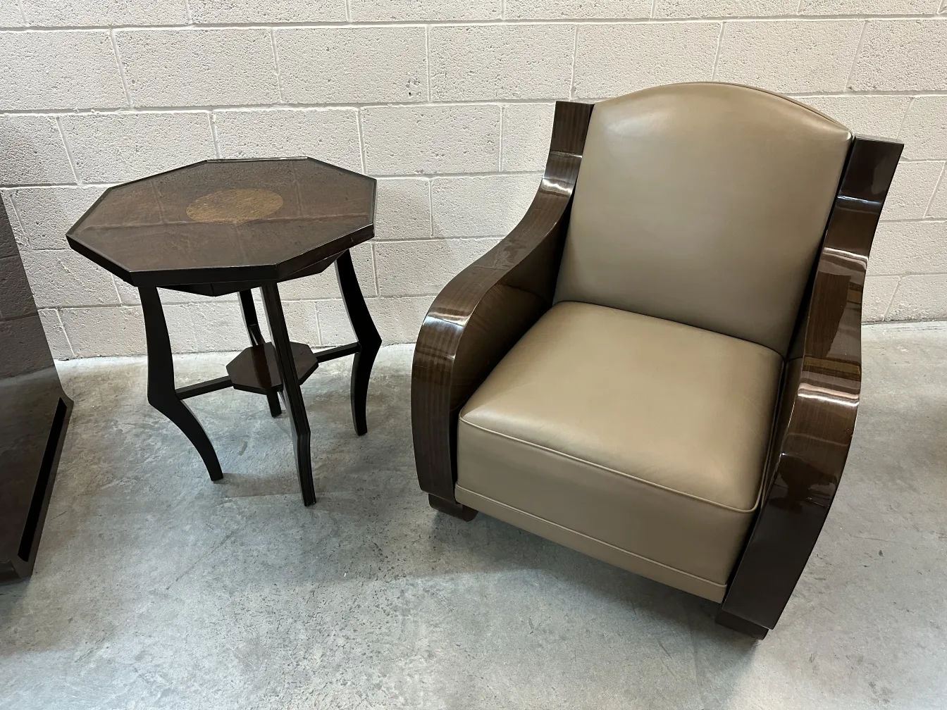 Antique small table in octagonal shape next to a modern chair