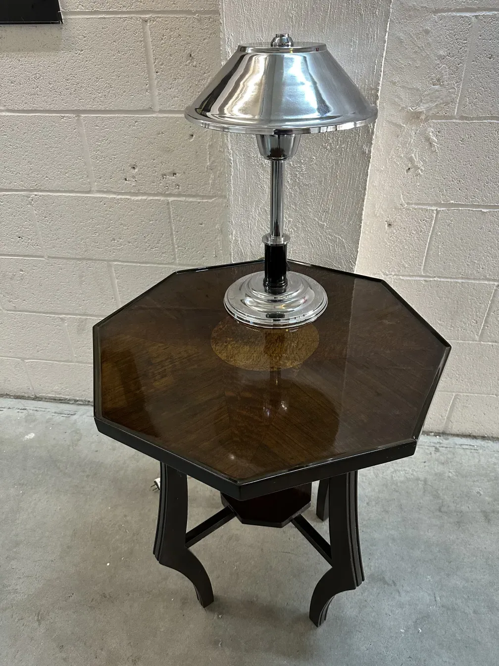 Antique hexagonal small table with modern lamp, cozy setting.