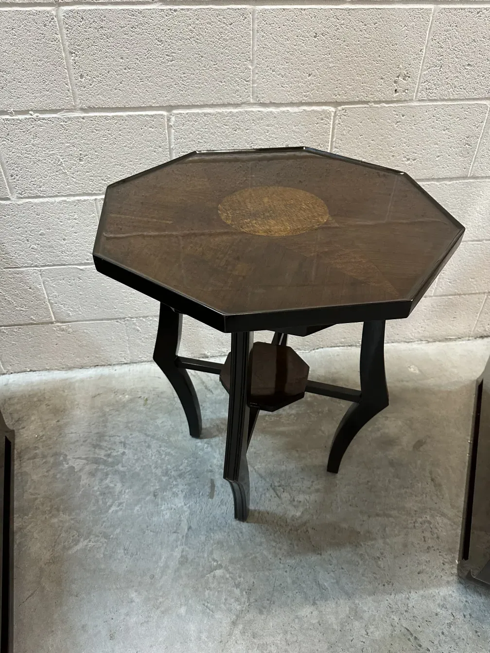 mesa pequena antiga octogonal com detalhes em um ambiente simples