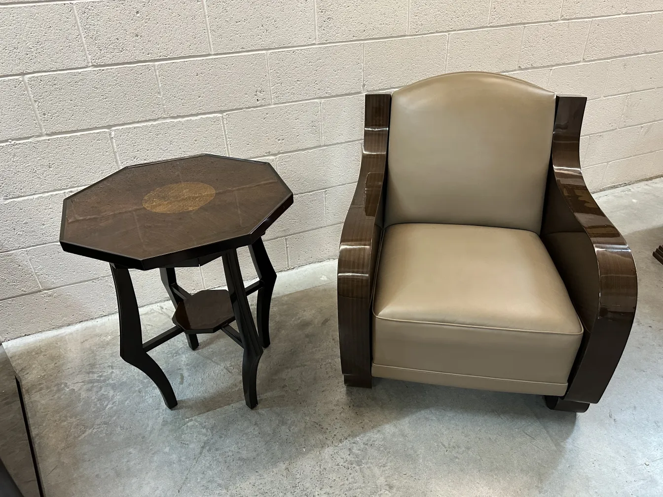 ancienne petite table octogonale avec décoration centrale, à côté d'un fauteuil