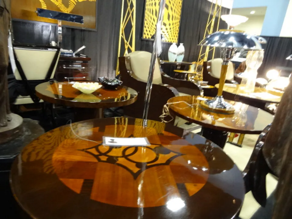 Antique kleiner Tisch mit glänzender Oberfläche in einem eleganten Umfeld mit Lampen und Stühlen.