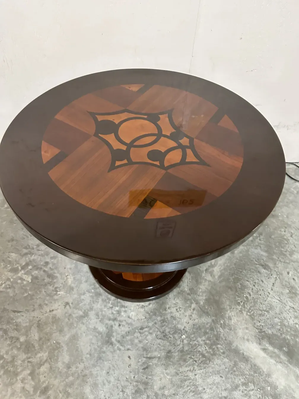 Mesita redonda antigua con detalle decorativo en la tapa