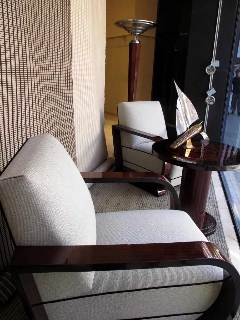 mesita antigua junto a sillones grises en ambiente moderno