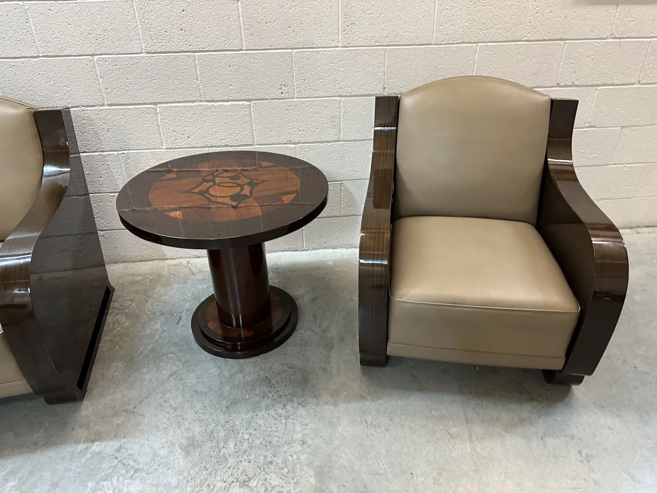 petite table ancienne décorative à côté de fauteuils dans un cadre clair