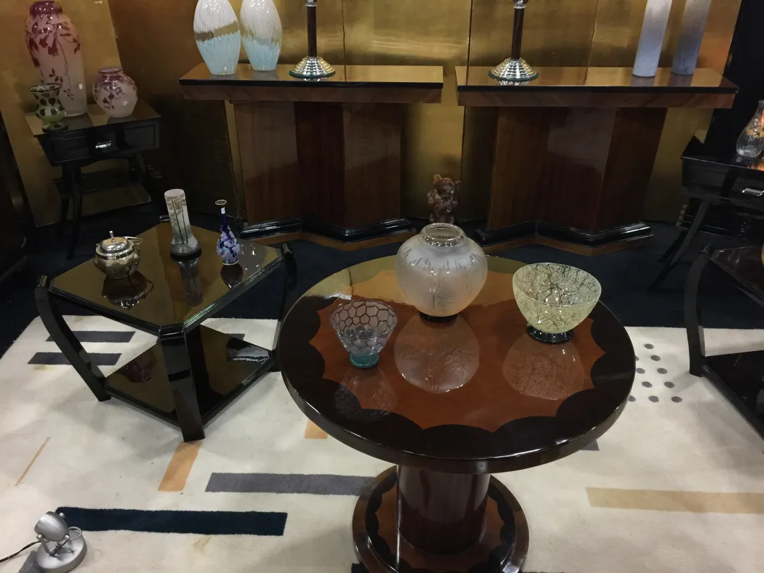 Mesinha antiga de sala com estilo elegante, cercada por vasos e itens decorativos.