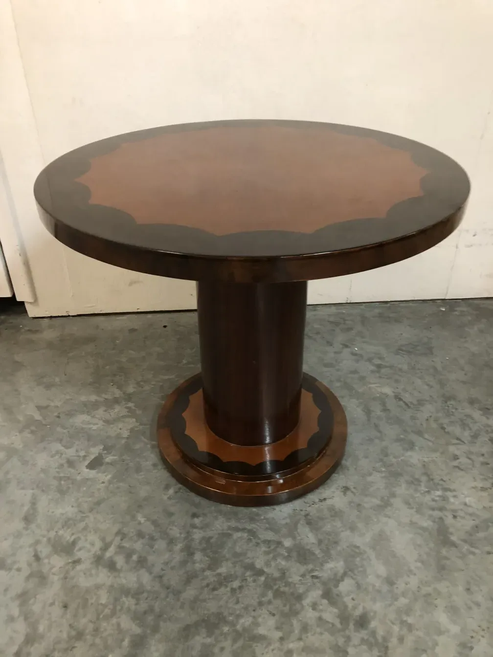 Petite table ancienne avec base ronde dans un cadre neutre