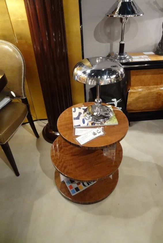 Tavolino antico con tre livelli in un ambiente elegante.