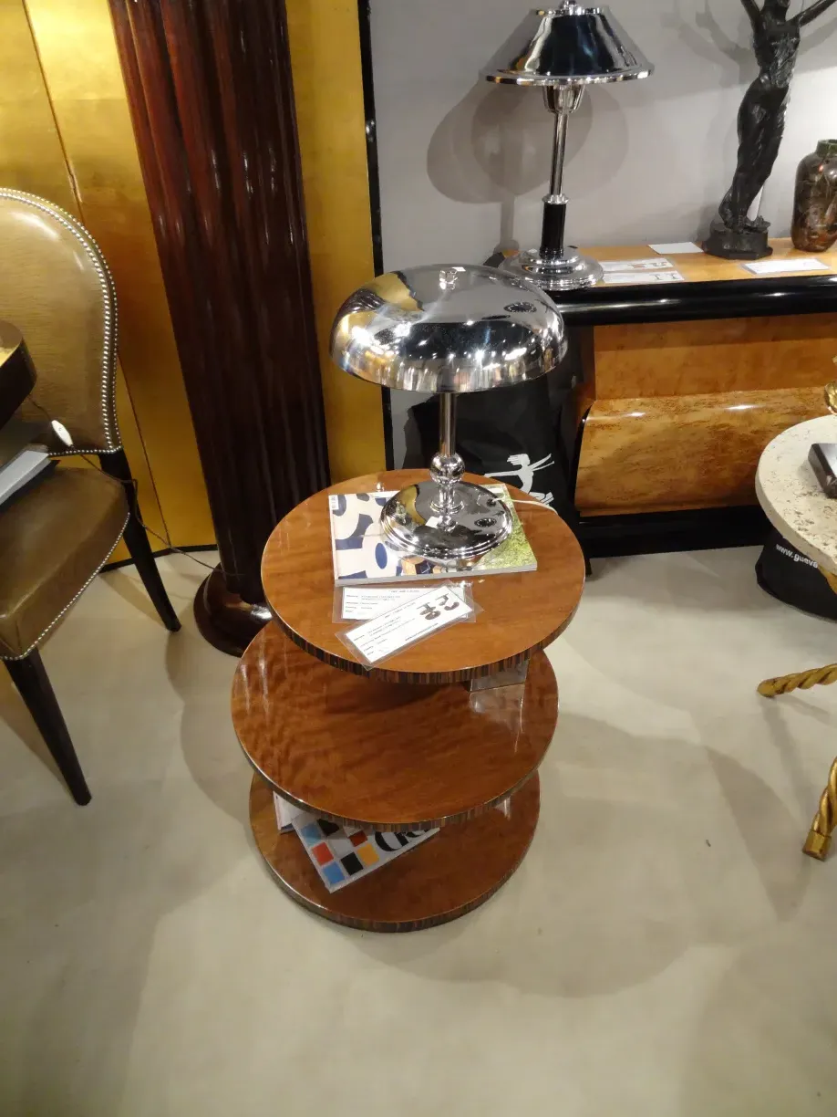 kleiner antiker Tisch mit Regalen, glänzende Metalllampe, elegantes Ambiente